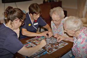 Parade House Activities - Staff and residents enjoying a puzzle at Parade House in Monmouth