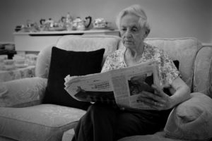 Resident reading a newspaper at Parade House in Monmouth