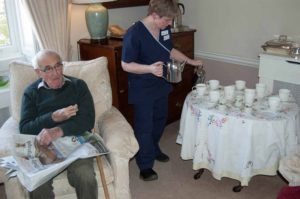 Staff serving tea to the resident of Parade House in Monmouth